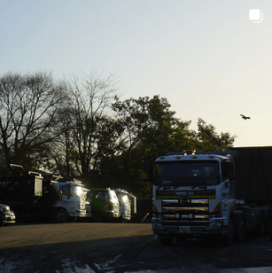 Depot overview/waste management carousel post with trucks and sunset
